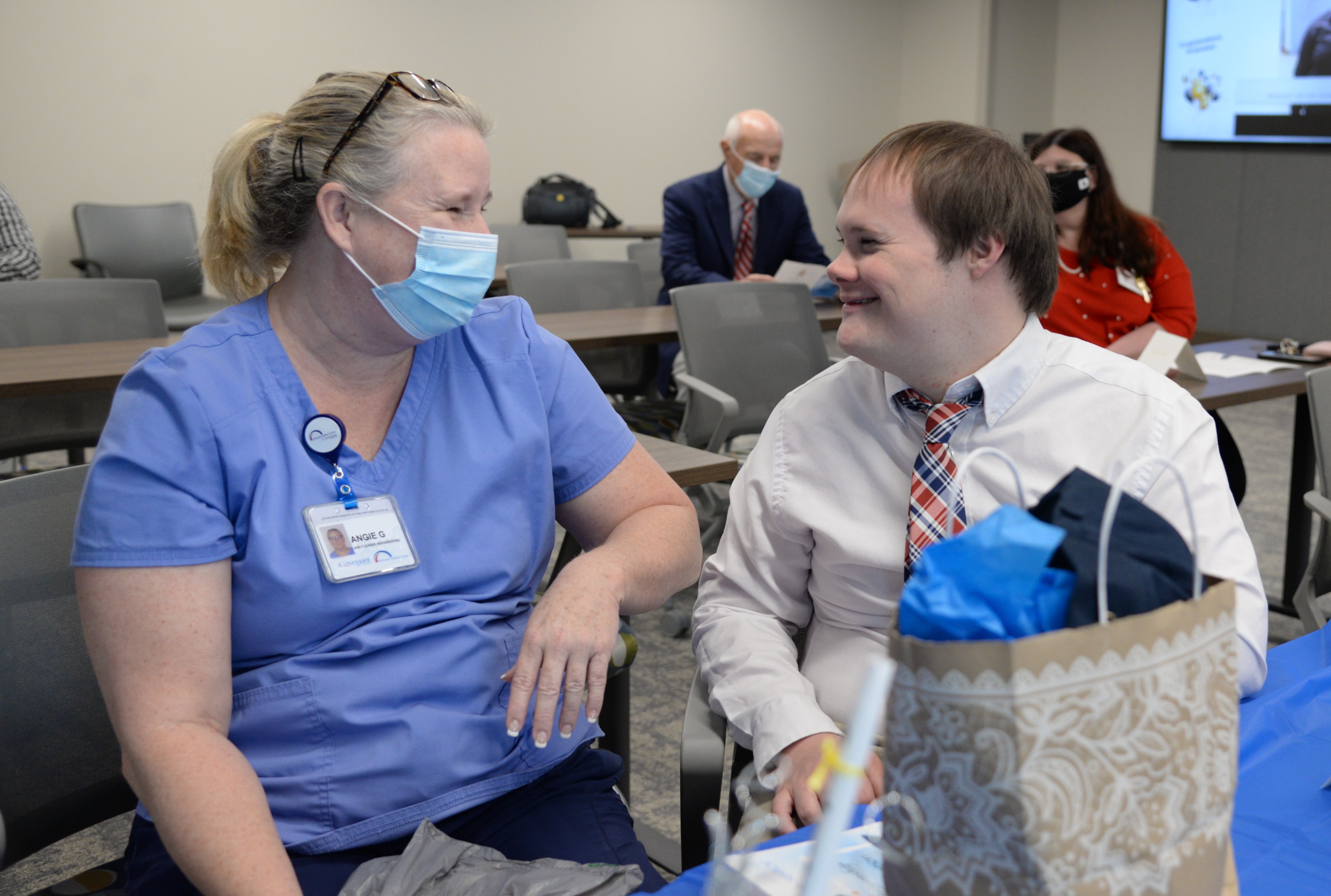 Halls High student Alex Webb speaks with a Parkwest Employee on Friday, May 14, before a graduation ceremony for Project SEARCH..